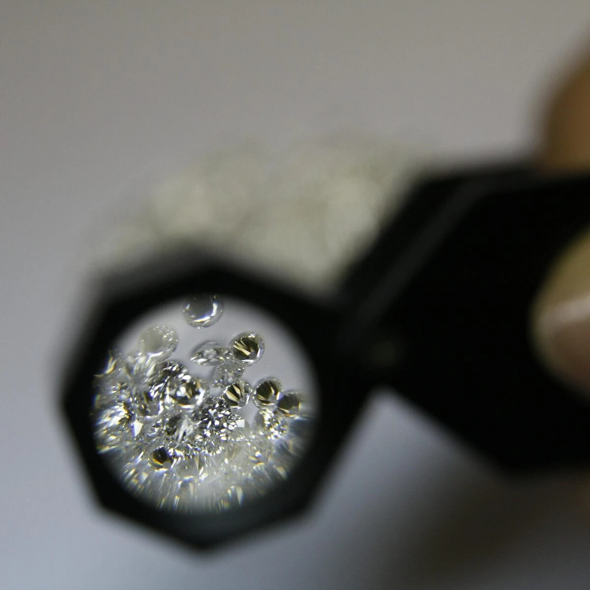 Lente gemmologica che ingrandisce un gruppo di diamanti